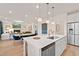 Bright kitchen with white countertops, stainless steel appliances, and island seating flowing into the living and dining areas at 148 Sugar Pine Drive, Franklinton, NC 27525