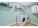 Well-organized laundry room with modern washer and dryer, ample shelving, and fresh blue accents at 148 Sugar Pine Drive, Franklinton, NC 27525