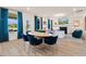 Open-concept living room with an oval wood table, surrounded by blue velvet chairs, and a view of the fireplace and TV at 148 Sugar Pine Drive, Franklinton, NC 27525