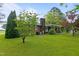 Expansive backyard featuring well-maintained lawn, mature trees and covered patio at 1517 Hodges Chapel Rd, Benson, NC 27504