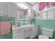 This bathroom features mint tiled walls, white cabinets and countertops, and natural lighting at 1517 Hodges Chapel Rd, Benson, NC 27504