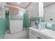 This bathroom features mint tiled walls, glass door shower, white cabinets, and white countertops at 1517 Hodges Chapel Rd, Benson, NC 27504
