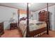 Cozy bedroom features a carpet floor, floral wallpaper and a four-poster bed with matching dresser at 1517 Hodges Chapel Rd, Benson, NC 27504