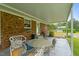 View of the brick home featuring a covered patio with seating area and table at 1517 Hodges Chapel Rd, Benson, NC 27504