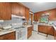 Cozy kitchen features warm wood cabinets, white appliances, and tiled floors with window views at 1517 Hodges Chapel Rd, Benson, NC 27504