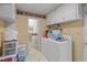 Functional laundry room with ample storage, adjacent bathroom, and modern washer and dryer at 1517 Hodges Chapel Rd, Benson, NC 27504