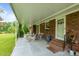 A covered patio with brick accents provides ample outdoor seating with views of the backyard at 1517 Hodges Chapel Rd, Benson, NC 27504