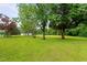 Exterior shot of green lawn with mature trees and outbuilding at 1517 Hodges Chapel Rd, Benson, NC 27504