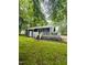 View of the backyard featuring a deck, sliding glass doors, and a well-maintained lawn at 1634 Hurdle Mills Rd, Roxboro, NC 27574