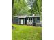 View of the backyard featuring a deck, sliding glass doors, and a well-maintained lawn at 1634 Hurdle Mills Rd, Roxboro, NC 27574
