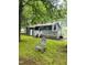 View of the backyard featuring a deck, sliding glass doors, and a well-maintained lawn at 1634 Hurdle Mills Rd, Roxboro, NC 27574