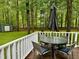 Exterior shot of wood deck with seating area surrounded by trees at 1634 Hurdle Mills Rd, Roxboro, NC 27574