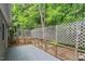 Exterior view of back deck with grey floorboards, lattice, and natural landscape at 1703 Berwickshire Cir, Raleigh, NC 27615