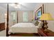 Bedroom featuring a four-poster bed, decorative lamps, and bright natural lighting at 1703 Berwickshire Cir, Raleigh, NC 27615