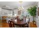 Elegant dining area featuring a chandelier, hardwood floors, and access to the kitchen at 1703 Berwickshire Cir, Raleigh, NC 27615