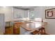 Well-lit kitchen area featuring white cabinetry, a breakfast bar, and modern appliances at 1703 Berwickshire Cir, Raleigh, NC 27615