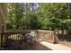 Outdoor back deck with wooded views featuring a patio table and chairs at 1816 Piperwood Ct, Durham, NC 27713