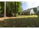 View of home's backyard showing the green grass and the partially wooded area at 1816 Piperwood Ct, Durham, NC 27713