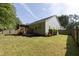 View of home's back exterior with enclosed porch, landscaped yard, and green grass at 1816 Piperwood Ct, Durham, NC 27713