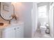 Bright bathroom with white vanity, large mirror and tiled floors at 1816 Piperwood Ct, Durham, NC 27713