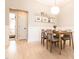 Bright dining area features modern light fixture, decorative shelving, and cozy seating for four at 1816 Piperwood Ct, Durham, NC 27713
