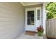 Inviting entryway featuring a glass paneled door, charming welcome mat, and potted flowers at 1816 Piperwood Ct, Durham, NC 27713