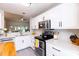 Bright kitchen features white cabinets, stainless steel appliances, and mosaic backsplash at 1816 Piperwood Ct, Durham, NC 27713