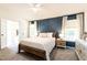 Stunning main bedroom with a blue accent wall, stylish furniture, and natural light at 1816 Piperwood Ct, Durham, NC 27713