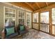 Covered porch area with comfortable seating, string lights, and screened windows at 1816 Piperwood Ct, Durham, NC 27713