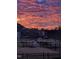Backyard featuring black metal fence, view of other homes and colorful sunset sky at 192 Logbridge Rd, Chapel Hill, NC 27516