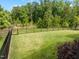 Spacious backyard with lush green lawn, black metal fence, and mature trees for privacy at 192 Logbridge Rd, Chapel Hill, NC 27516