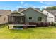 Backyard with large green lawn, wood deck with gas grill, and covered screened porch at 192 Logbridge Rd, Chapel Hill, NC 27516