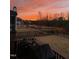 Spacious backyard with black metal fence and beautiful colorful sunset sky in a residential neighborhood at 192 Logbridge Rd, Chapel Hill, NC 27516