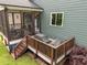 Exterior angle of covered porch & exterior deck with grill of a home with green siding at 192 Logbridge Rd, Chapel Hill, NC 27516