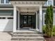Inviting front porch with stone steps, decorative pillars, and a charming entrance with double doors at 192 Logbridge Rd, Chapel Hill, NC 27516