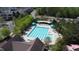 High angle view of a community pool with marked lanes, lounge chairs, and shaded picnic areas at 192 Logbridge Rd, Chapel Hill, NC 27516