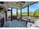 Cozy screened porch with a stone fireplace, comfortable seating, and ceiling fan for a relaxing outdoor space at 192 Logbridge Rd, Chapel Hill, NC 27516