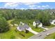 A view of a neighborhood home and pond, surrounded by lush, mature trees at 1969 Bowles Ave, Creedmoor, NC 27522
