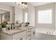 A bright bathroom features granite countertops, double sinks, and a soaking tub with a view at 1969 Bowles Ave, Creedmoor, NC 27522