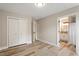Neutral bedroom with wood floors, double closet doors, and an adjacent bathroom at 1969 Bowles Ave, Creedmoor, NC 27522
