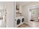 Convenient laundry area with washer, dryer, shelving, and a view into the bathroom at 1969 Bowles Ave, Creedmoor, NC 27522