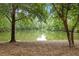 Scenic view of a tranquil pond surrounded by lush greenery and mature trees at 1969 Bowles Ave, Creedmoor, NC 27522