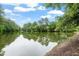 Scenic view of a serene pond reflecting lush green trees under a partly cloudy sky at 1969 Bowles Ave, Creedmoor, NC 27522