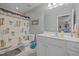 Beach-themed bathroom with white vanity, neutral tile floor, and shower with palm tree curtain at 2012 Sterling Hill Dr, Fuquay Varina, NC 27526