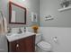 Stylish powder room featuring wainscoting, cherry vanity, decorative mirror, and elegant fixtures at 2012 Sterling Hill Dr, Fuquay Varina, NC 27526