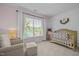 Charming Bedroom with shiplap accent wall, wooden crib, and cozy armchair near window at 2012 Sterling Hill Dr, Fuquay Varina, NC 27526