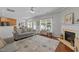 Cozy living room with a decorative fireplace, large windows, and a stylish rug at 2012 Sterling Hill Dr, Fuquay Varina, NC 27526