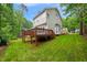 Home's exterior featuring a well-maintained yard, complemented by an expansive deck and lush greenery in a serene setting at 203 Lighthouse Way, Cary, NC 27511