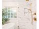 Shower with marble tile, gold hardware, and built-in shelving at 203 Lighthouse Way, Cary, NC 27511