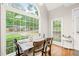 Dining area filled with natural light from large windows, wooden table with chairs, and hardwood flooring throughout at 203 Lighthouse Way, Cary, NC 27511